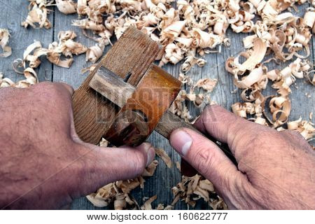 Traditional Woodworker Using Antique Wooden Mortise Gauge