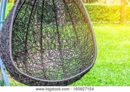 hanging bench seat chair in basket design on the green grass field
