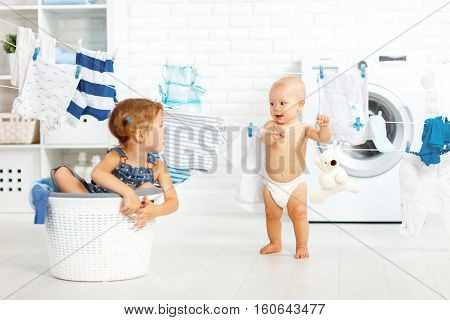 little helpers funny kids happy sister and brother in the laundry to wash clothes playing and laughing