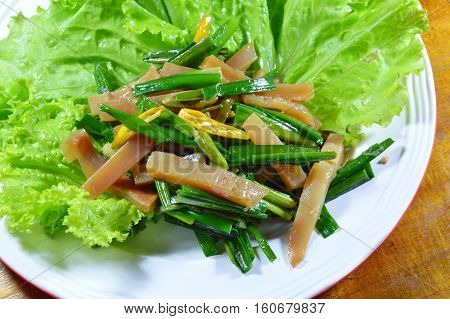 stir fried pickled crispy squid with garlic chives and lettuce on plate