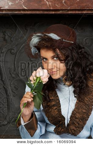 Portrait of a beautiful young victorian lady in front of a castle fireplace. Shot in the antique castle 