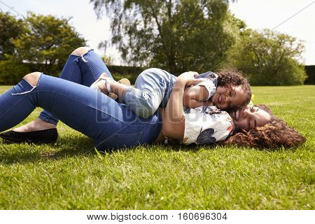 Mother and young daughter lying on grass, low angle close up