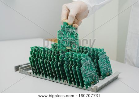 Microchip production factory. Technological process. Assembling the board. Computer expert. Manufacturing. Engineering. Chip. Professional. Technician.