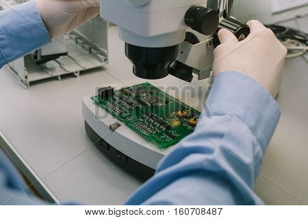 Microchip production factory. Technological process. Assembling the board. Computer expert. Manufacturing. Engineering. Chip. Professional. Technician.