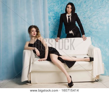 Two Fashionable Girls Sitting On The Armchair