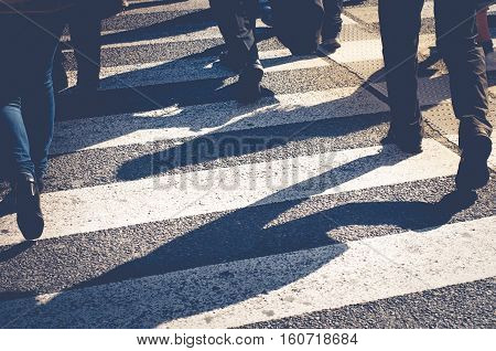 crowd of people crossing a street at the pedestrian crossing