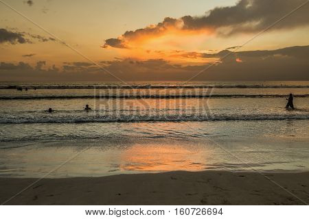 Beautiful sunset of Kuta Beach Bali Indonesia. Silhouettes of people at sunset on Kuta beach in Bali Indonesia