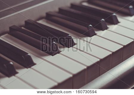 Piano keyboard black and white keys close-up musical instrument retro toning selective focus