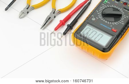 Multimeter probes needle nose pliers wire cutters screwdriver on white background