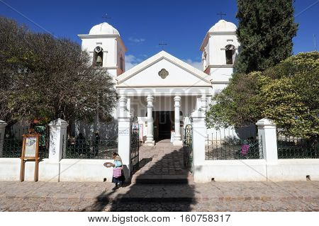Humahuaca Argentina - 24 January 2011: Incas woman walking in front of the church of Humahuaca on argentina andes