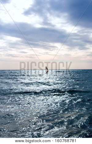 Group of windsurfers on boards in wavy sea. Lifestyle and sport completition concept. Group of people. Fun and leisure activity. Vertical composition.