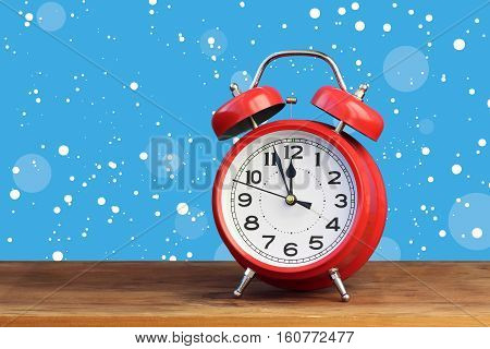 Red retro alarm clock at twelve o'clock amid flying snow. Midnight midday. Minutes about New year.