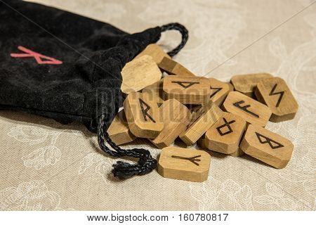 Wooden runes with black bag. Esoteric subjects.