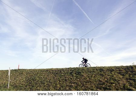 man on mountain bike on dutch dike in waterland near amsterdam and durgerdam