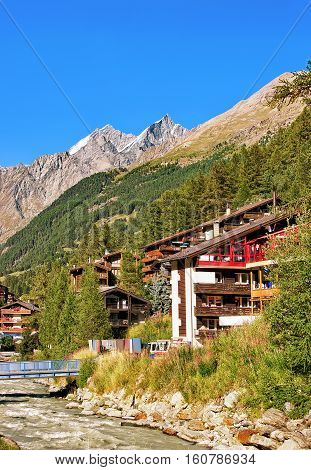Traditional Swiss Chalets And Gornera River In Resort City Zermatt