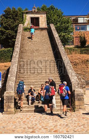 PORTOMARIN SPAIN - AUGUST 12: Pilgrims ascending the Roman staircase on August 12 2016