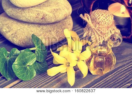 Essence and flower of forsythia on wooden background. Vintage toned