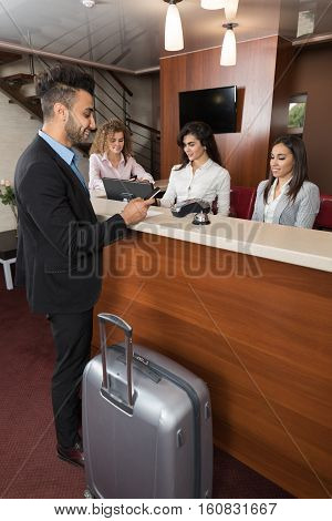 Business Man Arrive To Hotel Check In With Cell Phone Woman Receptionist Registration At Reception Counter