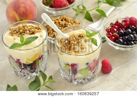 Dessert with fresh berries granola and custard in glasses