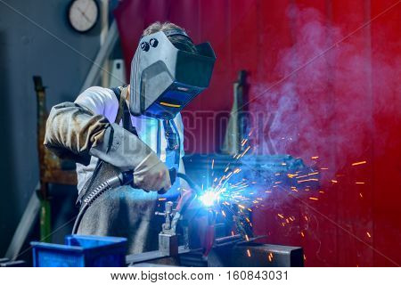 man electro- welding metal in the factory