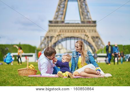 Happy Family Of Three Having Picnic In Paris