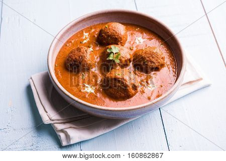 malai kofta curry - classic North Indian dish. vegetarian alternative to meatballs served with tandoori roti or indian bread and green salad, selective focus