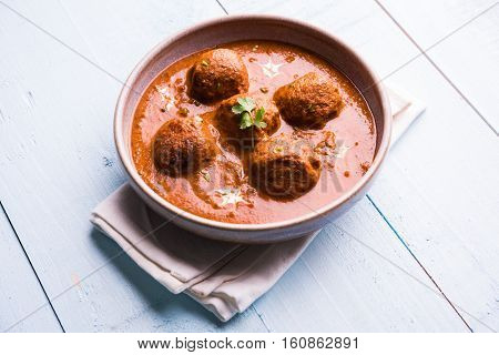 malai kofta curry - classic North Indian dish. vegetarian alternative to meatballs served with tandoori roti or indian bread and green salad, selective focus