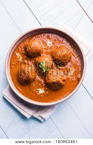 malai kofta curry - classic North Indian dish. vegetarian alternative to meatballs served with tandoori roti or indian bread and green salad, selective focus