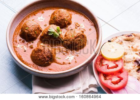 malai kofta curry - classic North Indian dish. vegetarian alternative to meatballs served with tandoori roti or indian bread and green salad, selective focus