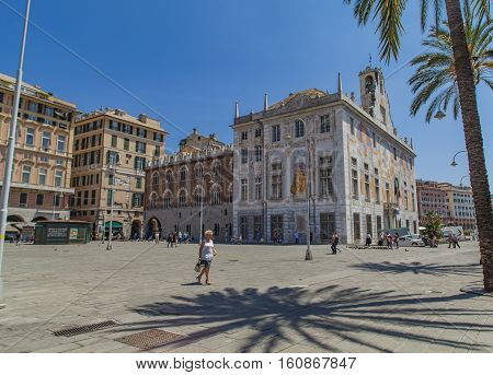 GENOA, ITALY - JUNE 2, 2015: Unidentified people by Palazzo San Giorgio in Genoa Italy. Palace was built in 1260 and facade was refrescoed in the late 19th century