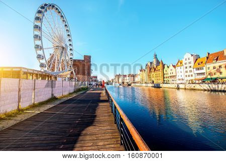 Morning view on the riverside of Motlawa river with beautiful buildings and viepoint wheel in the old town of Gdansk, Poland