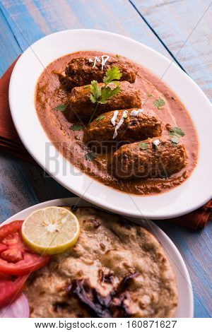 malai kofta curry - classic North Indian dish. vegetarian alternative to meatballs served with tandoori roti or indian bread and green salad, selective focus
