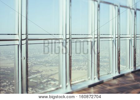 View from skyscraper window inner bright chrome and glass modern contemporary interior with reflections cityscape outside Dubai tilt shift shooting