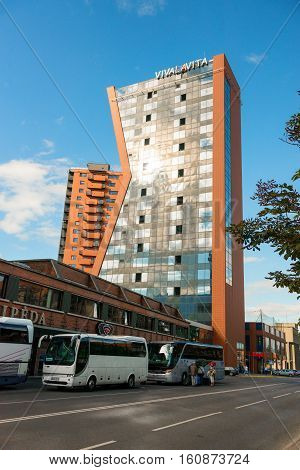 KLAIPEDA LITHUANIA - JULY 11 2013: Touristic buses with tourists nearthe hotel in Klaipeda Lithuania. It is the third largest city in Lithuania and the capital of Klaipeda County