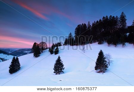 dramatic sunrise over snowy mountains Todtnauberg Germany