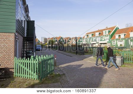 Marken, Netherlands, 22 november 2016: tourists walk in housing area of dutch village Marken on cold day in november