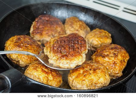 Frying homemade meatballs in black iron pan in fine broth