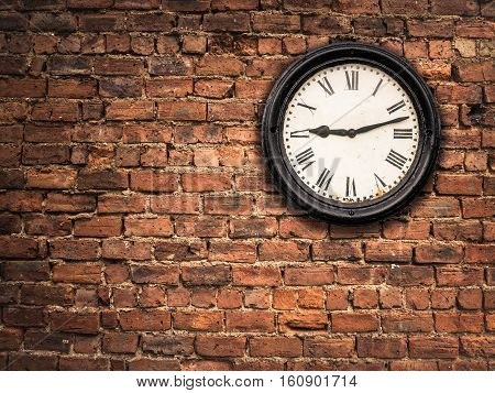 A Vintage Station Clock On A Red Brick Wall With Copy Space