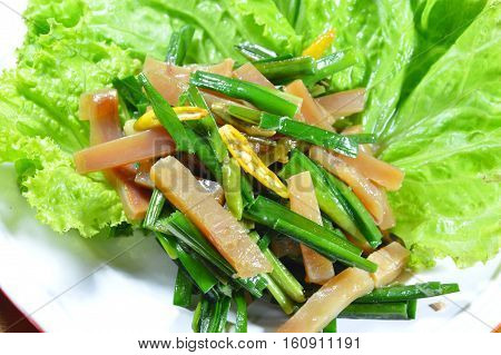 stir fried pickled crispy squid with garlic chives and lettuce on dish