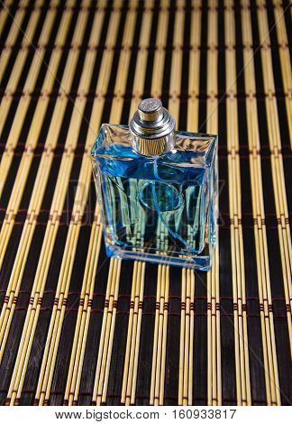 Bottle of men perfume on a bamboo mat