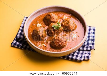 malai kofta curry - classic North Indian dish. vegetarian alternative to meatballs served with tandoori roti or indian bread and green salad, selective focus