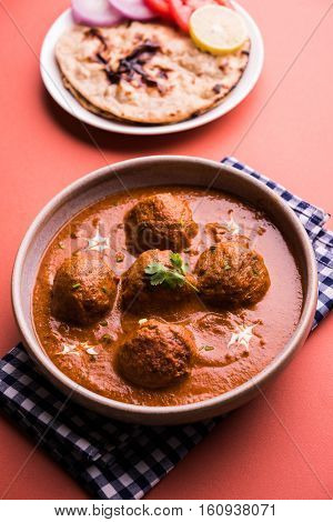 malai kofta curry - classic North Indian dish. vegetarian alternative to meatballs served with tandoori roti or indian bread and green salad, selective focus
