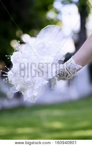 Bride hold lace rose bouquet her hand on breen background