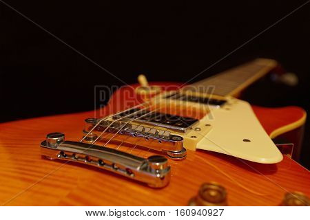 Solid body electric jazz guitar closeup on the black background. Selective focus.