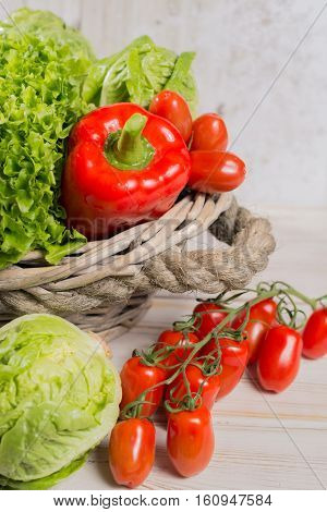 Ingredients for fresh spring healthy green salad- green and red frech lettuce salad leaves paprika tomatoes - healthy low calorie food