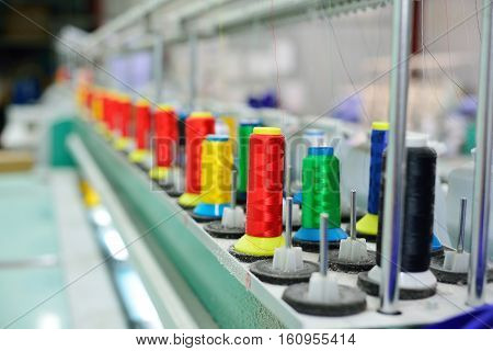 Spools of thread in the sewing equipment. The concept of sewing production.