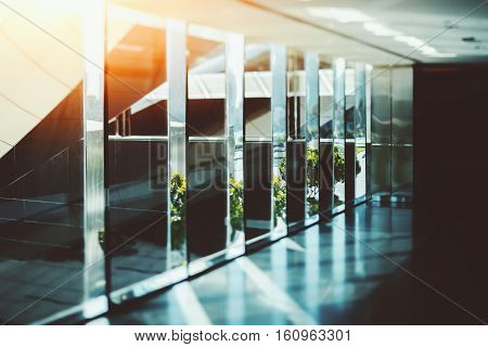 Abstract dark office interior background the sun rays glass chrome columns and windows
