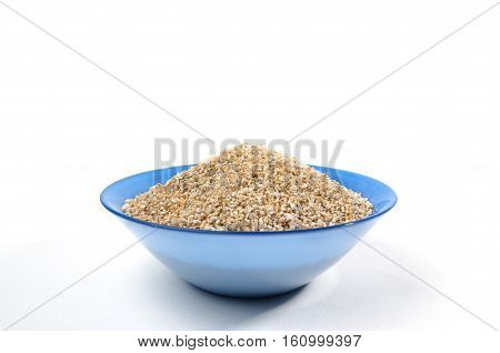 Blue bowl of barley grits isolated on white. On center