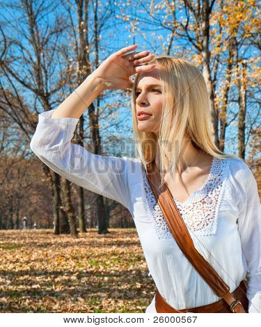 Fiatal nő ferde szemmel nézi az őszi színes park