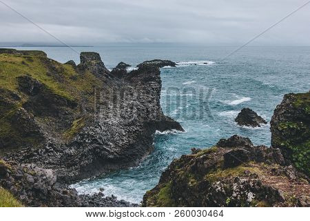 Scenic View Of Beautiful Cliffs In Front Of Blue Ocean In Arnarstapi, Iceland On Cloudy Day